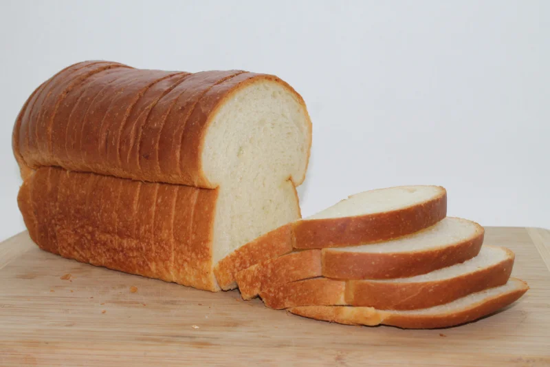 A sliced loaf of bread on a wooden board